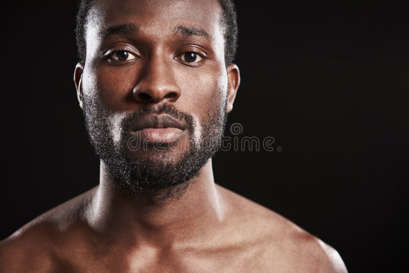 Stäng sig upp av en afro amerikansk man som ser kameran royaltyfri foto Stäng sig upp av en afro amerikansk man som ser kameran royaltyfri foto
