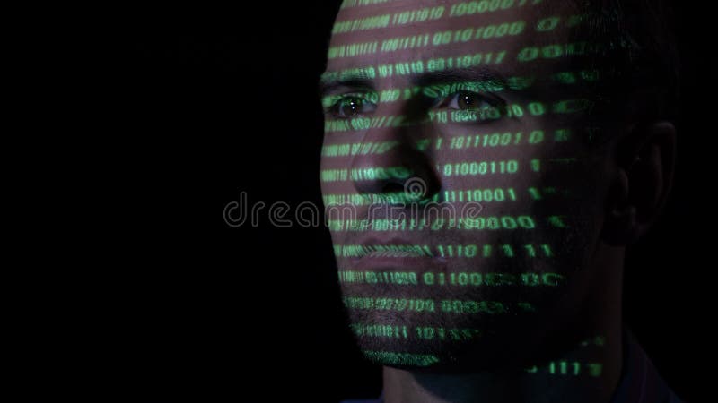 Stäng sig upp av en vuxen en hacker med skägget som arbetar på en dator, medan gröna kodtecken projekteras på hans framsida -