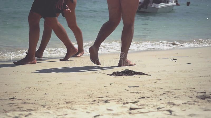 Stäng sig upp av fot som går på guld- sand på stranden med havvågor Ferie för sommarsemester långsam rörelse 1920x1080
