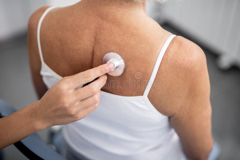 Stäng sig upp av stetoskopet på baksidan av patienten royaltyfri fotografi Stäng sig upp av stetoskopet på baksidan av patienten royaltyfri fotografi
