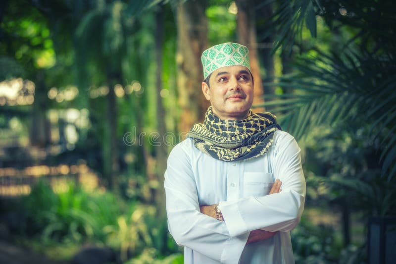 Stäng sig upp av vuxet pakistanskt muslimmananseende och korsa armen arkivfoto Stäng sig upp av vuxet pakistanskt muslimmananseende och korsa armen arkivfoto