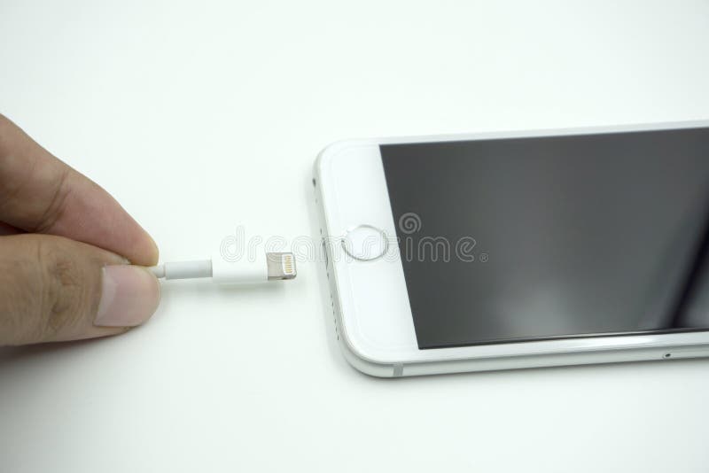 Stäng sig upp bild av den nya äppleiphonen 6s med den laddande cablen arkivbild Stäng sig upp bild av den nya äppleiphonen 6s med den laddande cablen arkivbild