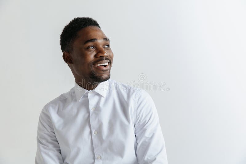 Stäng sig upp ståenden av en lycklig ung afrikansk amerikanman som skrattar mot grå bakgrund royaltyfria foton Stäng sig upp ståenden av en lycklig ung afrikansk amerikanman som skrattar mot grå bakgrund royaltyfria foton