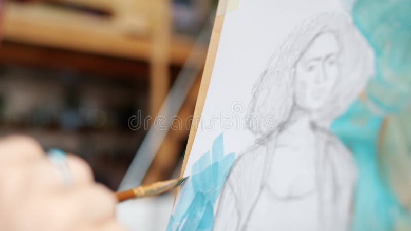 Stängning av flickors handmålning av kvinnors porträtt med vattenfärger i studio