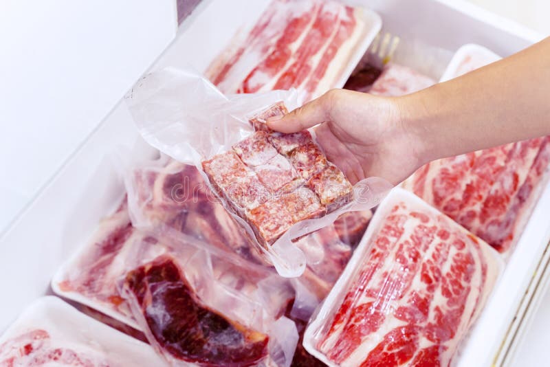 Stängning av handplockning av ett paket med rött kött fotografering för bildbyråer