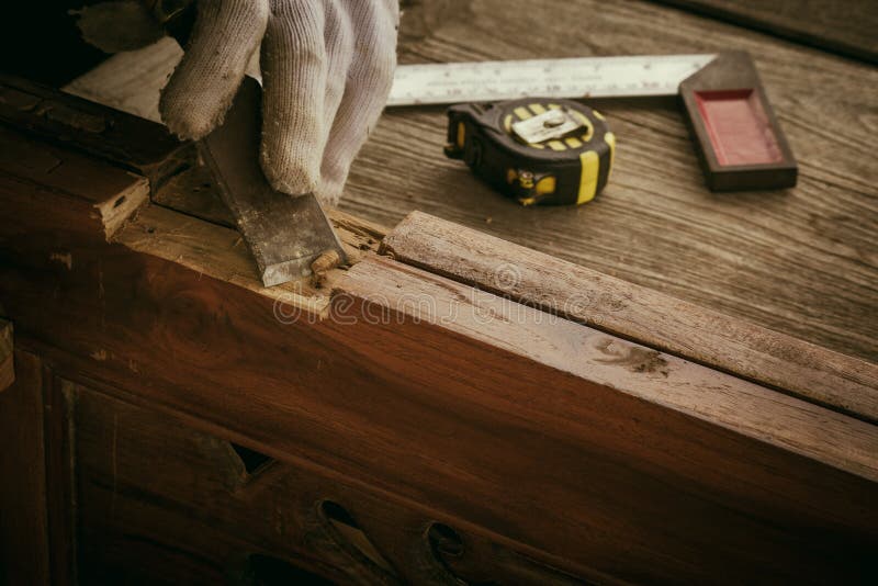 Close up the chisel to sharpen the wood plank. Close up the chisel to sharpen the wood plank