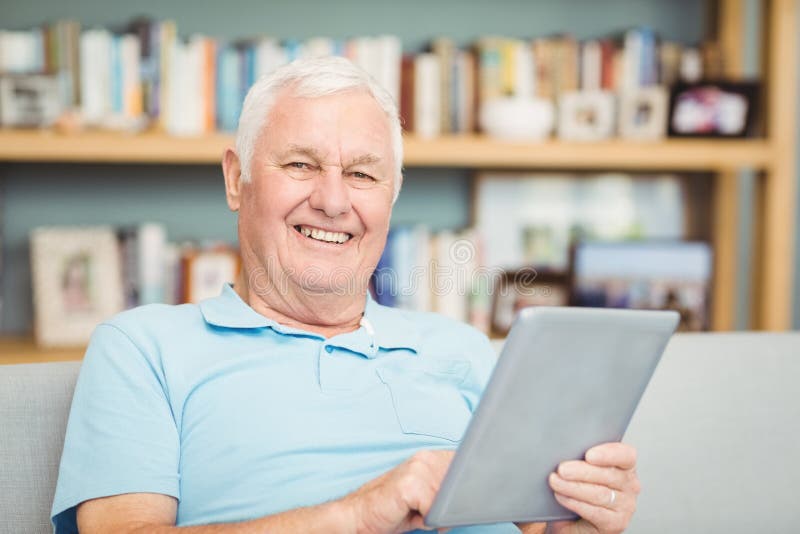 Stående av att le den höga mannen som använder den digitala minnestavlan royaltyfri foto Stående av att le den höga mannen som använder den digitala minnestavlan royaltyfri foto