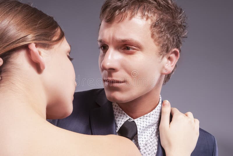Stående av att älska Caucasian par som tillsammans poserar Mot gr? f?rger fotografering för bildbyråer Stående av att älska Caucasian par som tillsammans poserar Mot gr? f?rger fotografering för bildbyråer