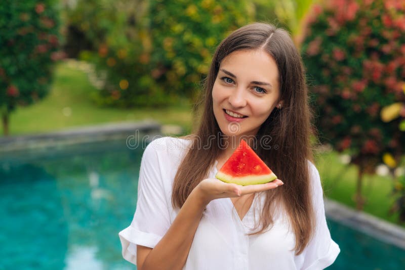 Stående av den charmiga le flickainnehavskivan av den saftiga vattenmelon i hennes hand arkivbild Stående av den charmiga le flickainnehavskivan av den saftiga vattenmelon i hennes hand arkivbild