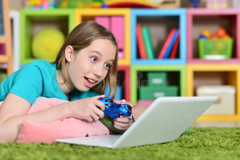 St? ende av den gulliga lilla flickan som spelar dataspelen arkivfoto