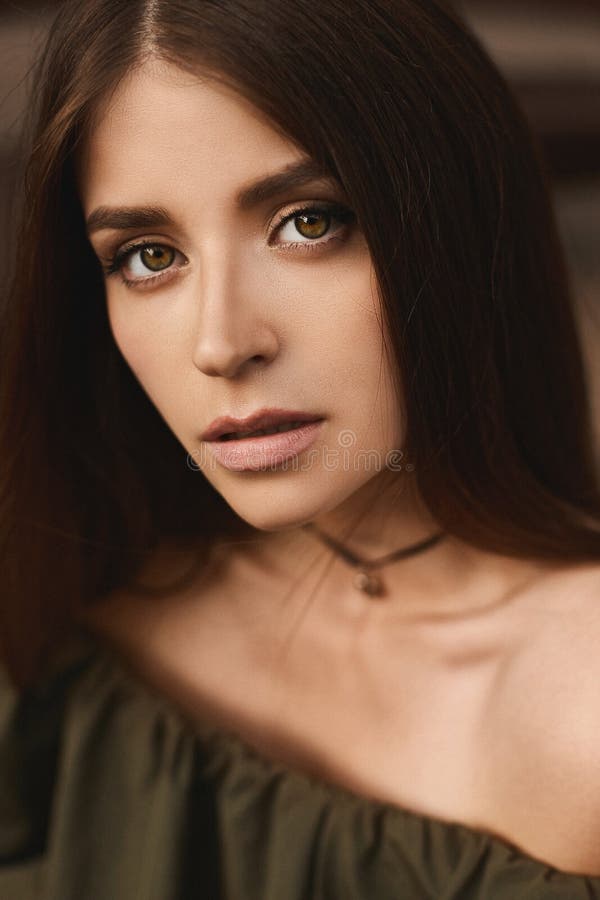 Stående av den härliga brunettmodellflickan med djupt - gröna ögon och med försiktig makeup i trendig mörker-gräsplan klänning arkivfoto Stående av den härliga brunettmodellflickan med djupt - gröna ögon och med försiktig makeup i trendig mörker-gräsplan klänning arkivfoto