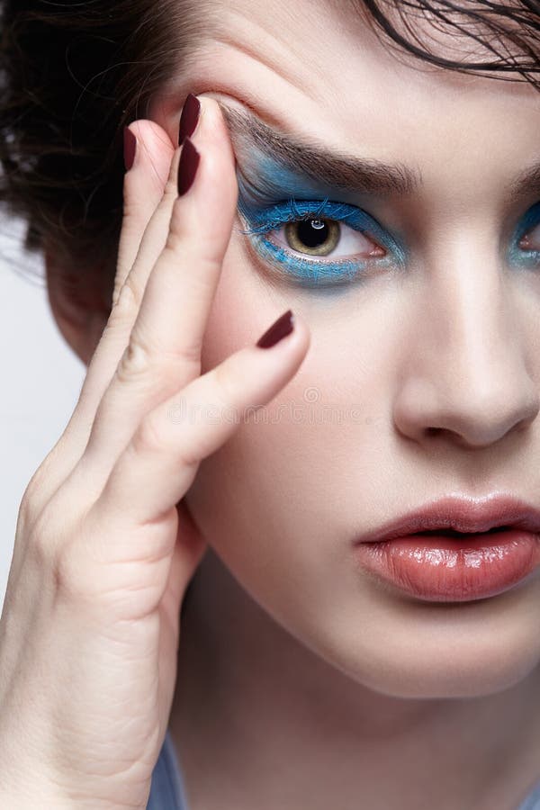 Stående av den kvinnliga kvinnan med ovanlig skönhetmakeup och vått hår och blått skuggasmink arkivbild Stående av den kvinnliga kvinnan med ovanlig skönhetmakeup och vått hår och blått skuggasmink arkivbild