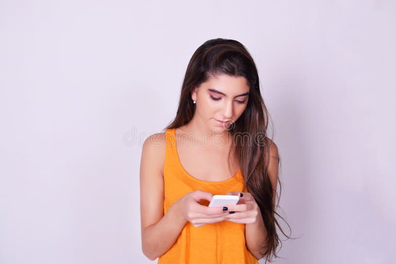 Stående av den latinamerikanska/caucasian unga kvinnan som använder en mobil phon royaltyfria foton Stående av den latinamerikanska/caucasian unga kvinnan som använder en mobil phon royaltyfria foton
