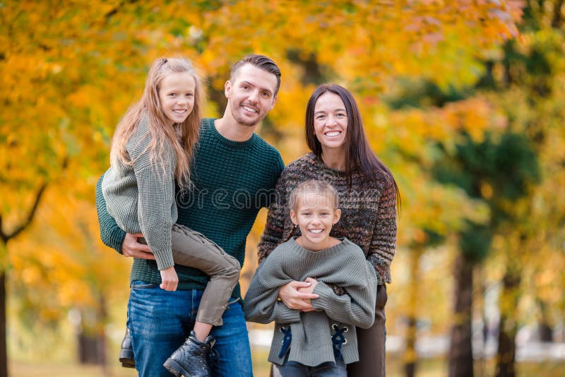 Stående av den lyckliga familjen av fyra i höst royaltyfri foto Stående av den lyckliga familjen av fyra i höst royaltyfri foto
