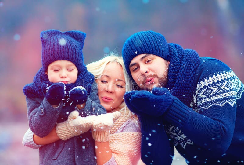 Stående av den lyckliga familjen som utomhus blåser vintersnö royaltyfri fotografi Stående av den lyckliga familjen som utomhus blåser vintersnö royaltyfri fotografi