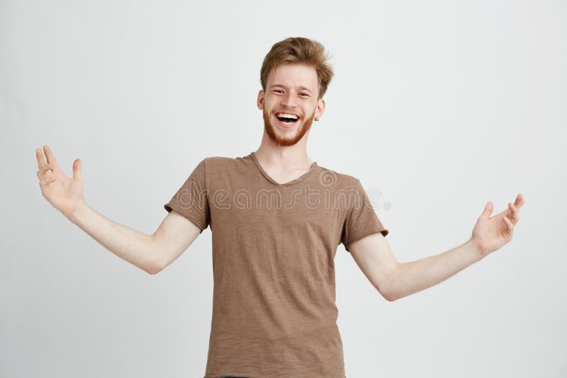 Stående av den lyckliga gladlynta positiva unga mannen som skrattar fröjden som gör en gest se kameran över vit bakgrund royaltyfria bilder Stående av den lyckliga gladlynta positiva unga mannen som skrattar fröjden som gör en gest se kameran över vit bakgrund royaltyfria bilder