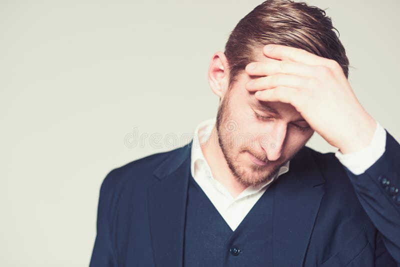 Stående av den tänkande affärsmannen med handen på hans huvud Skäggig grabb i den vita skjortan och blå dräkt som lider från royaltyfri foto Stående av den tänkande affärsmannen med handen på hans huvud Skäggig grabb i den vita skjortan och blå dräkt som lider från royaltyfri foto