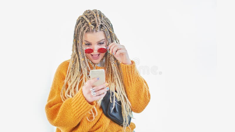 Stående av den undrade kvinnan, upphetsad student, chockad flickvän som har den smarta telefonmobiltelefonen i händer som håller arkivfoton Stående av den undrade kvinnan, upphetsad student, chockad flickvän som har den smarta telefonmobiltelefonen i händer som håller arkivfoton
