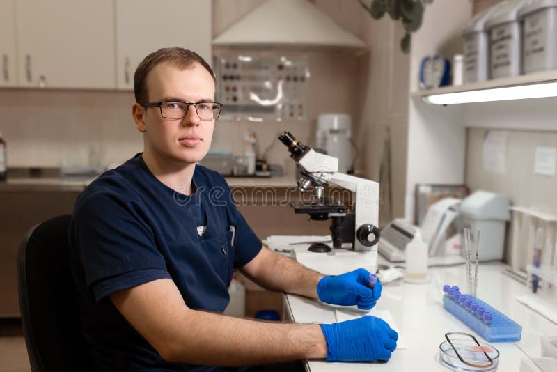 Stående av den unga caucasian manliga forskaren, den medicinska arbetaren, tech eller doktorandarbeten i modernt biologiskt labor royaltyfri fotografi Stående av den unga caucasian manliga forskaren, den medicinska arbetaren, tech eller doktorandarbeten i modernt biologiskt labor royaltyfri fotografi