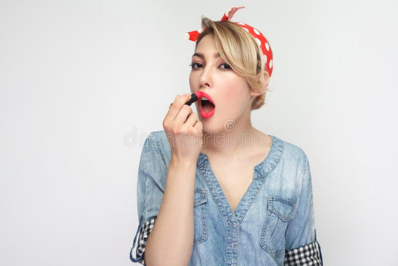 Stående av den unga kvinnan för härlig sexuell skönhetblogger i tillfällig blå grov bomullstvillskjorta med makeup och rött huvud arkivfoton Stående av den unga kvinnan för härlig sexuell skönhetblogger i tillfällig blå grov bomullstvillskjorta med makeup och rött huvud arkivfoton