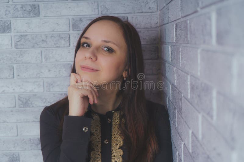 Stående av det härliga lyckaanseendet för ung kvinna på grå bakgrund för tegelsten för vägg för cementtexturgrunge arkivfoto Stående av det härliga lyckaanseendet för ung kvinna på grå bakgrund för tegelsten för vägg för cementtexturgrunge arkivfoto