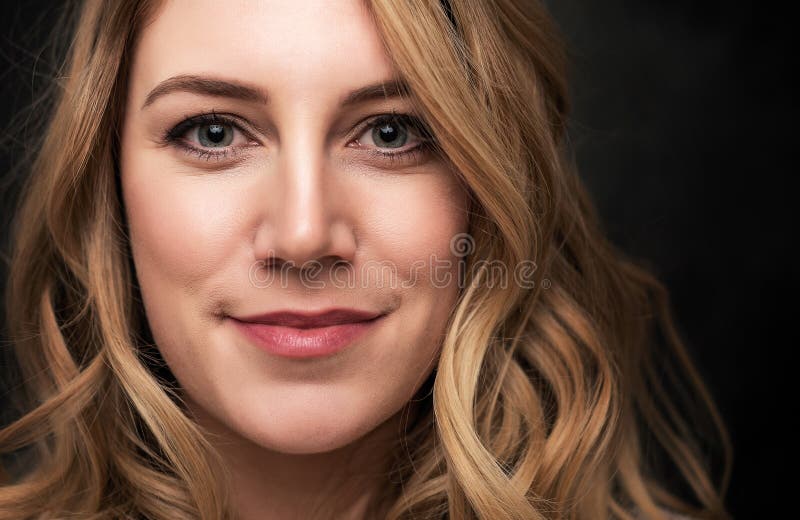 Stående av en attraktiv ung blond kvinna på en svart bakgrund arkivbilder Stående av en attraktiv ung blond kvinna på en svart bakgrund arkivbilder