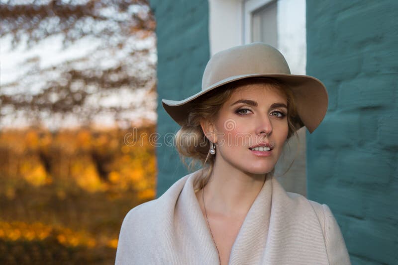 Portrait of a beautiful woman in a hat and coat outdoor . retro wedding style 50-ies. toned photo. Portrait of a beautiful woman in a hat and coat outdoor . retro wedding style 50-ies. toned photo.