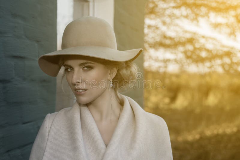 Portrait of a beautiful woman in a hat and coat outdoor . retro wedding style 50-ies. toned photo. Portrait of a beautiful woman in a hat and coat outdoor . retro wedding style 50-ies. toned photo.