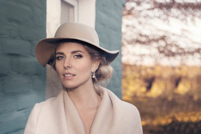 Portrait of a beautiful woman in a hat and coat outdoor . retro wedding style 50-ies. toned photo. Portrait of a beautiful woman in a hat and coat outdoor . retro wedding style 50-ies. toned photo.