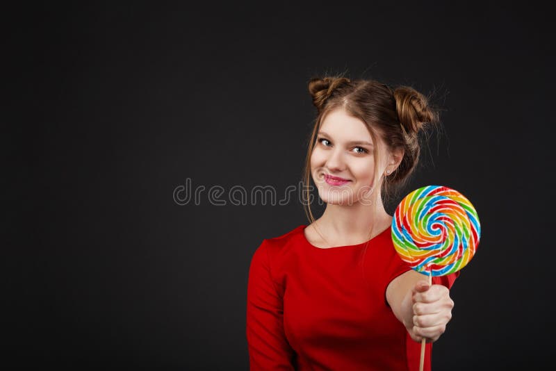 Stående av en le ung härlig flicka i en röd klänning med a arkivfoto Stående av en le ung härlig flicka i en röd klänning med a arkivfoto