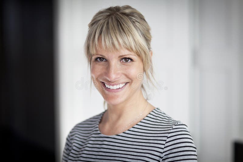 Stående av en mogen kvinna som ler på kameran arkivbild Stående av en mogen kvinna som ler på kameran arkivbild