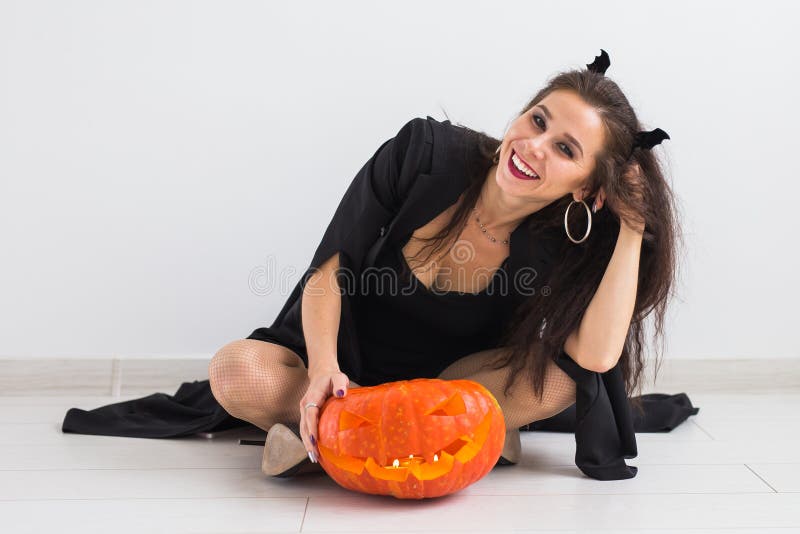 Stående av en stilfull brunettkvinna med halloween pumpa royaltyfri bild Stående av en stilfull brunettkvinna med halloween pumpa royaltyfri bild