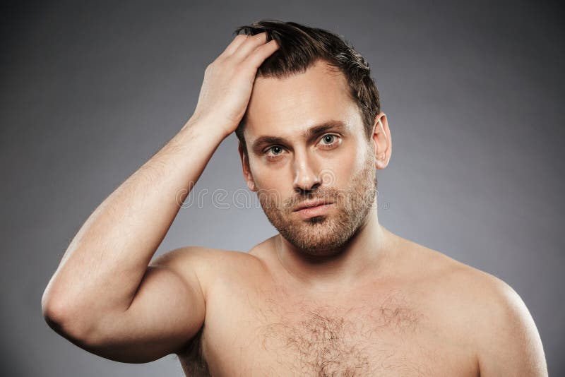 Stående av en stilig shirtless man som fixar hans hår arkivfoton Stående av en stilig shirtless man som fixar hans hår arkivfoton