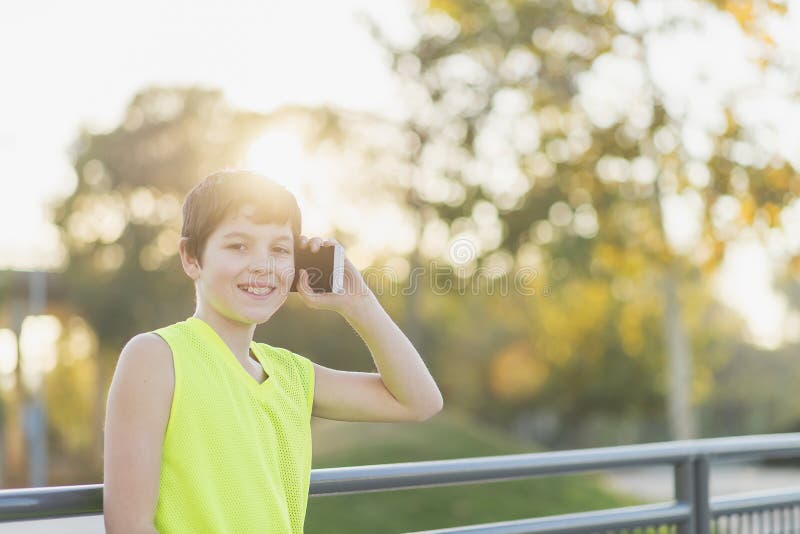 Stående av en tonåring som ler genom att använda hans smartphone royaltyfri fotografi Stående av en tonåring som ler genom att använda hans smartphone royaltyfri fotografi