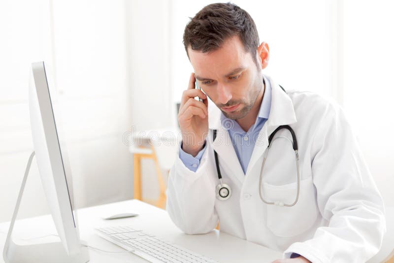 Stående av en ung doktor som ringer en patient arkivfoton Stående av en ung doktor som ringer en patient arkivfoton
