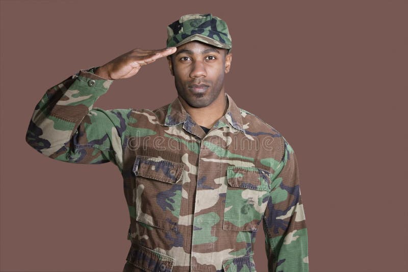 Stående av en ung soldat för afrikansk amerikanUSA som Marine Corps saluterar över brun bakgrund