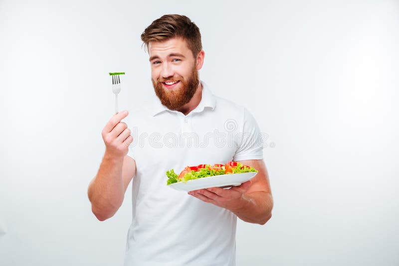 Stående av en ung stilig tillfällig man som äter sallad arkivbilder Stående av en ung stilig tillfällig man som äter sallad arkivbilder