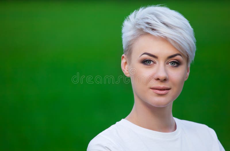 Stående av ett ungt, härligt och att le flickan blondinen med kort hår royaltyfri fotografi Stående av ett ungt, härligt och att le flickan blondinen med kort hår royaltyfri fotografi