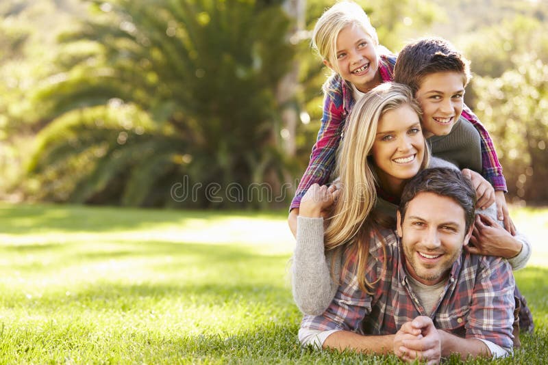 Stående av familjen som ligger på gräs i bygd royaltyfri fotografi Stående av familjen som ligger på gräs i bygd royaltyfri fotografi