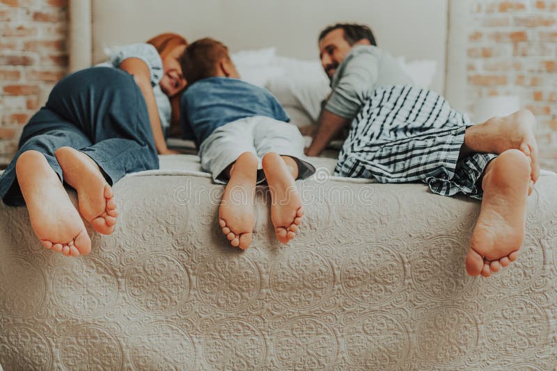 Stående av familjen tre par av fot i säng royaltyfri foto Stående av familjen tre par av fot i säng royaltyfri foto