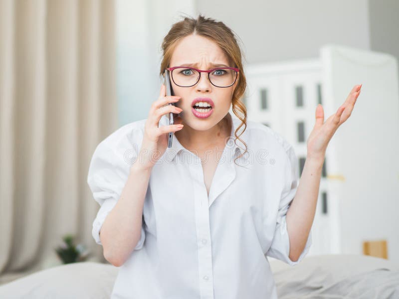 Portrait of frustrated young woman freelancer holding cell phone and screaming angrily as she can`t make online payment or having some problem with connection. Portrait of frustrated young woman freelancer holding cell phone and screaming angrily as she can`t make online payment or having some problem with connection.