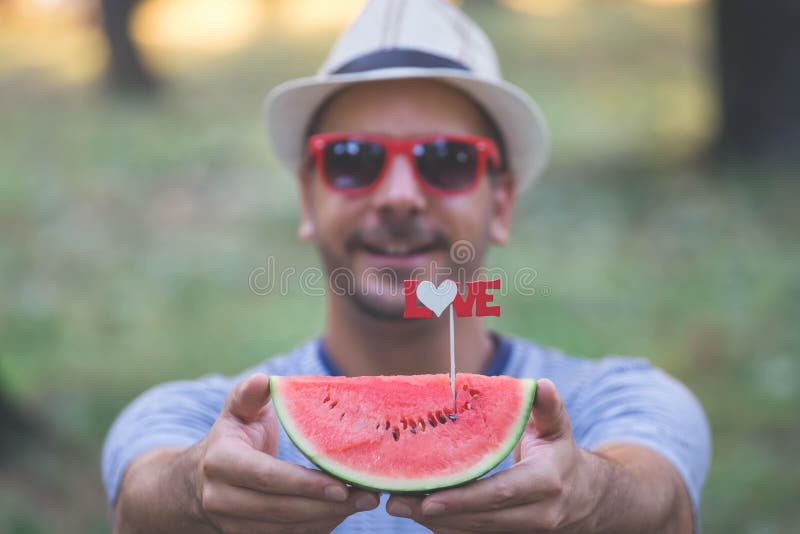 Stående av skivan för hipstergrabbinnehav av vattenmelon med förälskelsetecknet arkivbilder Stående av skivan för hipstergrabbinnehav av vattenmelon med förälskelsetecknet arkivbilder