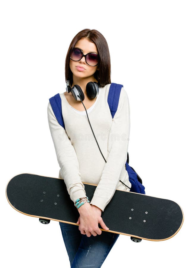 Stående av tonåringen med skateboarden, hörlurar och ryggsäcken arkivfoton
