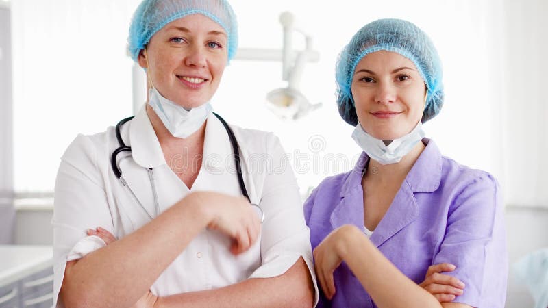 Stående av två professionellkvinnligdoktorer som står i sjukhusrum Läkare med stetoskopet