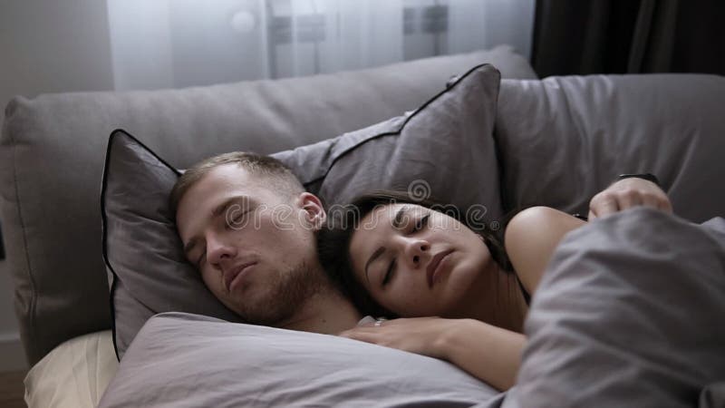 Stående av unga caucasian par som hemma sover i sängen på de gråa sängarken Frukost för en person