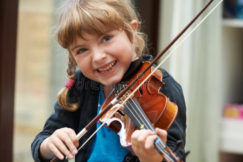 Stående av unga flickan som lär att spela fiolen
