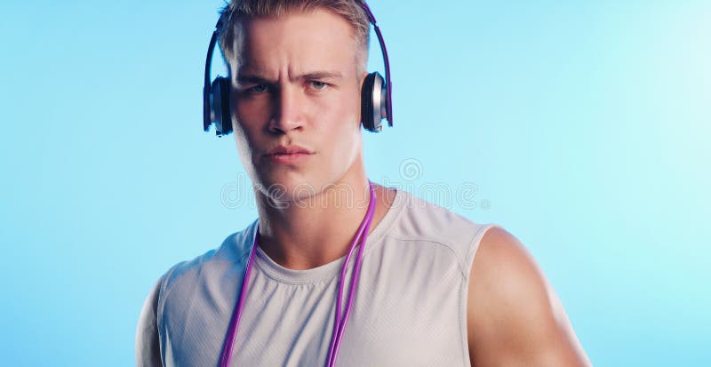 Stående hörlurar och seriös man i studio för att träna eller hoppa på rep för att passa eller hälsa. Musikidrottare och royaltyfria bilder