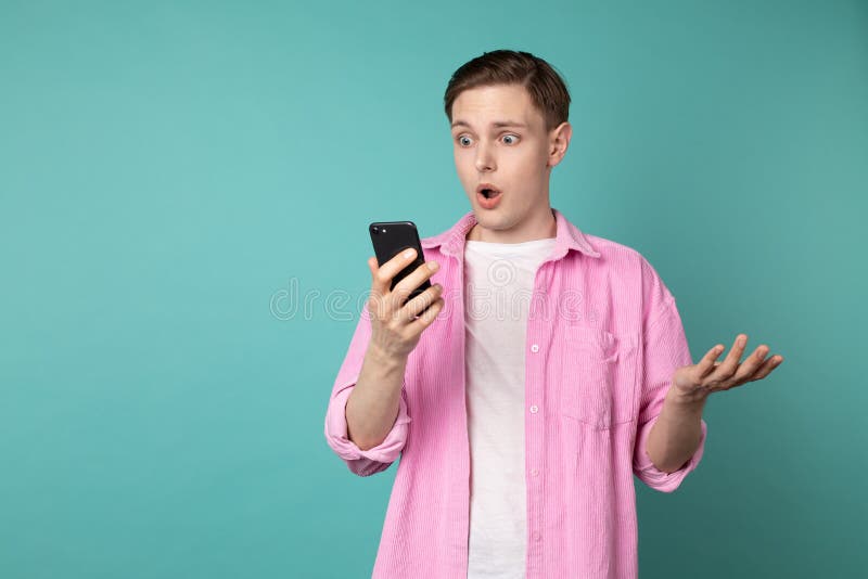 Ståenden av den chockade och läskiga framsidan av den europeiska mannen får skriken från smartphonen royaltyfri fotografi Ståenden av den chockade och läskiga framsidan av den europeiska mannen får skriken från smartphonen royaltyfri fotografi