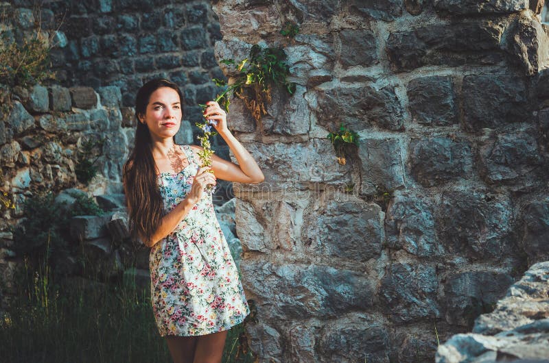 Ståenden av den unga romantiska kvinnan med långt hår, röda kanter och manikyr i den vita klänningen blommar Attraktiv flicka i S royaltyfria bilder Ståenden av den unga romantiska kvinnan med långt hår, röda kanter och manikyr i den vita klänningen blommar Attraktiv flicka i S royaltyfria bilder