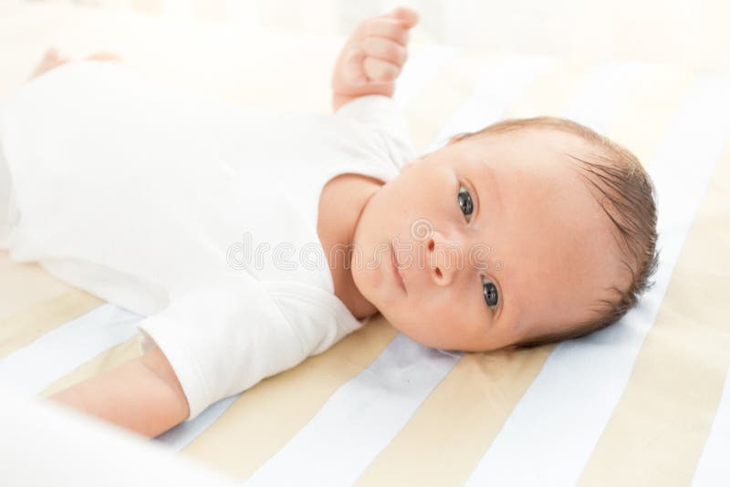 Ståenden av gulligt nyfött behandla som ett barn att ligga i säng och att se kameran fotografering för bildbyråer Ståenden av gulligt nyfött behandla som ett barn att ligga i säng och att se kameran fotografering för bildbyråer